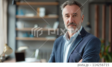 Portrait of a distinguished senior man in a smart casual outfit standing in an office setting 114256715