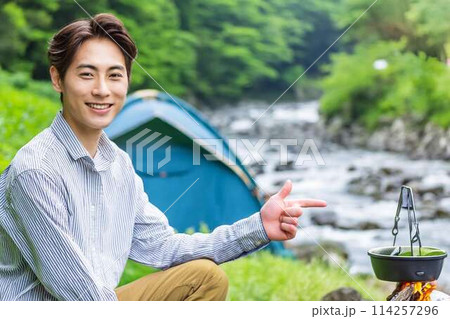 川原で一人キャンプする青年 114257296