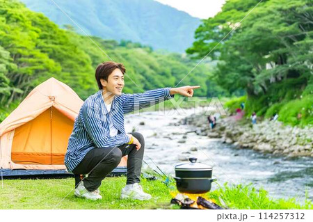 川原で一人キャンプする青年 114257312
