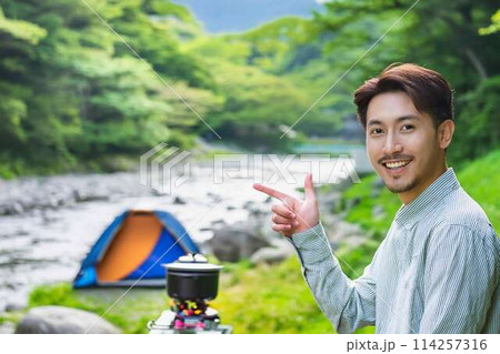 川原で一人キャンプする青年 114257316