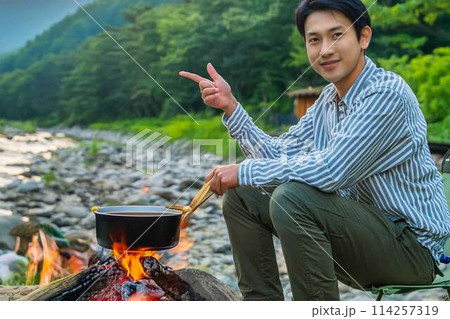 川原で一人キャンプする青年 114257319