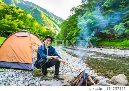 川原で一人キャンプする青年 114257325