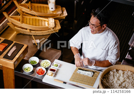 chef laughing at something while working in the kitchen chef laughing at something while working in the kitchen 114258166