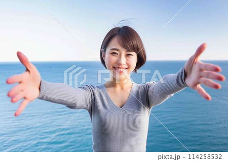 両手を広げてウェルカムポーズをする女性 114258532