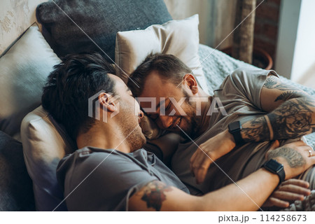 A homosexual couple on bed in studio with loft interior 114258673