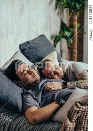 Two handsome gay men, nude in bed together cuddling and smiling one of them has visible pecs and defined abs Two handsome gay men, nude in bed together cuddling and smiling one of them has visible pecs and defined abs 114258682