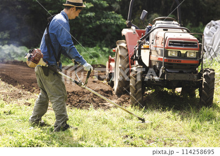 草刈機で雑草を刈る男性 114258695