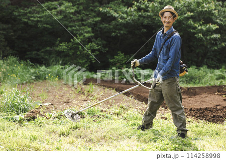 草刈機で雑草を刈る男性 114258998