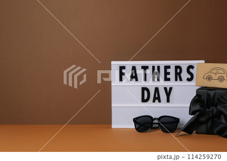 Inscription on a white chalkboard father's day, on a brown background, with gifts. Inscription on a white chalkboard father's day, on a brown background, with gifts. 114259270