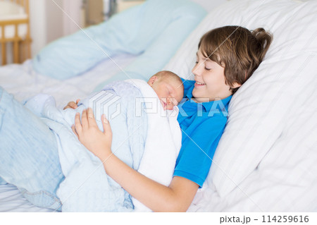 Siblings meet newborn baby in hospital 114259616