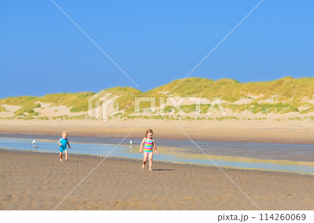 Kids playing on beach. Children play at sea. 114260069