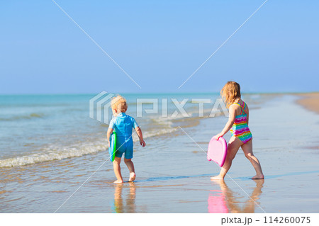 Kids playing on beach. Children play at sea. 114260075
