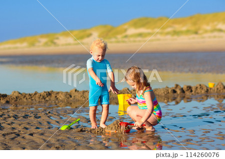 Kids playing on beach. Children play at sea. Kids playing on beach. Children play at sea. 114260076