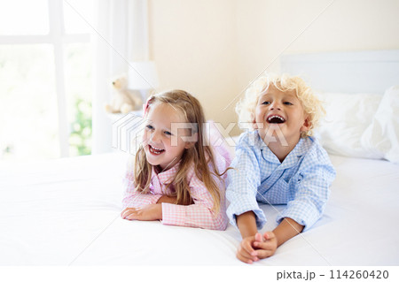 Kids in bed. Children in pajamas. Family bedroom. 114260420