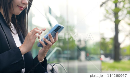 街角でスマホを使う女性ビジネスウーマン 114260967