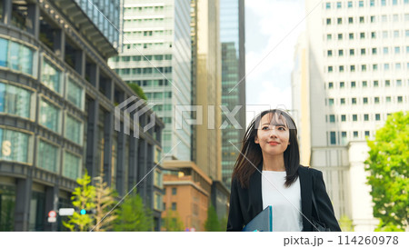 都市で風をきって歩く女性ビジネスパーソン 114260978
