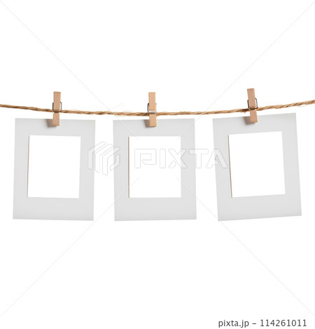 close up of a 3 blank note papers, photo frame on a rope with clothespins white background close up of a 3 blank note papers, photo frame on a rope with clothespins white background 114261011