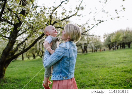 Portrait of beautiful mature first time mother with small toddler, outdoors in spring nature. Portrait of beautiful mature first time mother with small toddler, outdoors in spring nature. 114261932