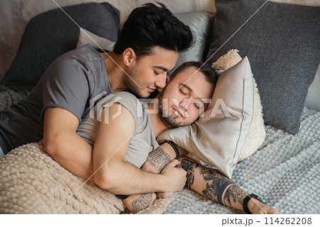 A homosexual couple on bed in studio with loft interior 114262208
