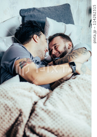 Positive delighted non-traditional couple sleeping together 114262315