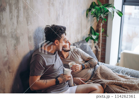 Perfect morning begins with lover and coffee in bed. Two guys resting in bed. Perfect morning begins with lover and coffee in bed. Two guys resting in bed. 114262361