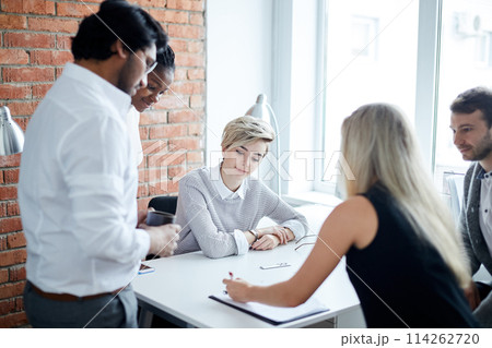 young fair-haired leader giving directions to new employees young fair-haired leader giving directions to new employees 114262720