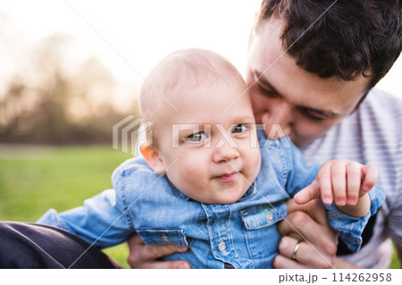 Father holding little toddler boy playing, having fun during warm spring day. Father's day concept. Father holding little toddler boy playing, having fun during warm spring day. Father's day concept. 114262958