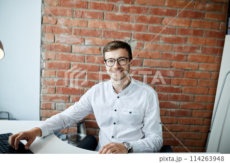 positive unshaven office worker looking at the camera 114263948