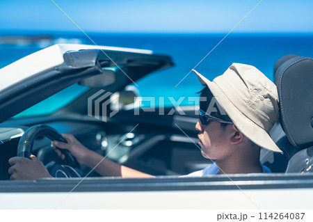 晴れた日にオープンカーを運転する若い男性 114264087
