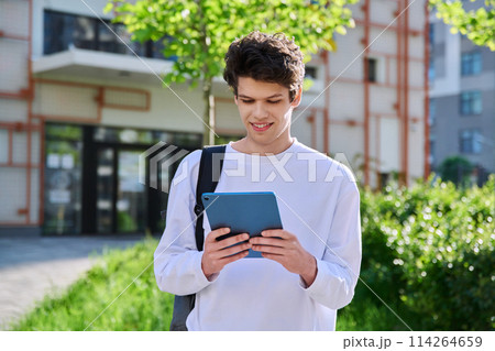 Young guy college student using digital tablet outdoor 114264659