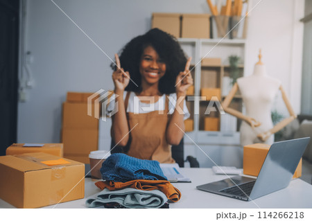 Startup SME small business entrepreneur of freelance Asian woman wearing apron using laptop and box to receive and review orders online to prepare to pack sell to customers, online sme business ideas. Startup SME small business entrepreneur of freelance Asian woman wearing apron using laptop and box to receive and review orders online to prepare to pack sell to customers, online sme business ideas. 114266218