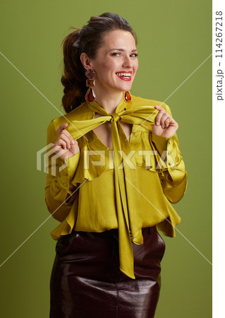 smiling fit woman in green blouse isolated on green background 114267218