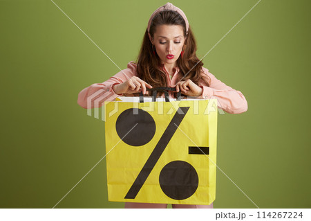 surprised modern woman isolated on green background 114267224