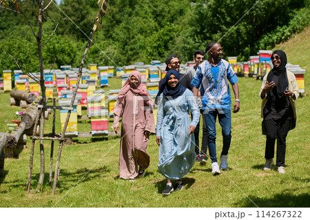A diverse group of young friends and entrepreneurs explore small honey production businesses in the natural setting of the countryside. A diverse group of young friends and entrepreneurs explore small honey production businesses in the natural setting of the countryside. 114267322