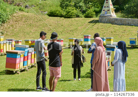 A diverse group of young friends and entrepreneurs explore small honey production businesses in the natural setting of the countryside. A diverse group of young friends and entrepreneurs explore small honey production businesses in the natural setting of the countryside. 114267336