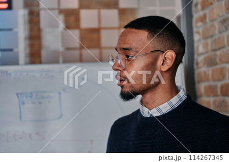 African American businessman delivers a compelling presentation of his business strategy to his colleagues, fostering collaboration and forward thinking African American businessman delivers a compelling presentation of his business strategy to his colleagues, fostering collaboration and forward thinking 114267345