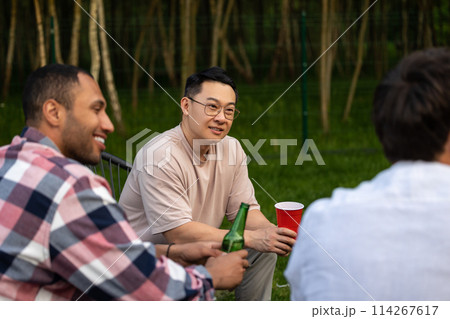 Cheerful friends enjoying cold beer at backyard party Cheerful friends enjoying cold beer at backyard party 114267617