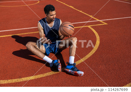 Handsome guy having basketball workout on outdoor summer playground 114267699