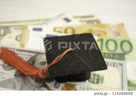 Graduation gap hat on Euro and US dollar banknotes money, Education study fee learning teach concept. Graduation gap hat on Euro and US dollar banknotes money, Education study fee learning teach concept. 114268689