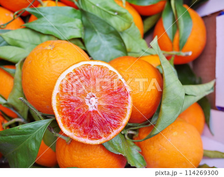 A bunch of oranges with one of them cut open A bunch of oranges with one of them cut open 114269300