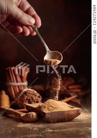 Cinnamon powder is poured into a wooden bowl. Cinnamon powder is poured into a wooden bowl. 114271484