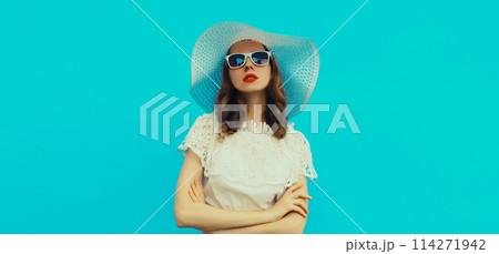 Beautiful caucasian young woman model posing wearing white summer straw hat on blue background 114271942