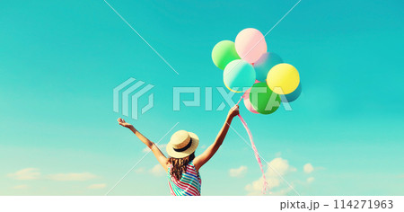 Happy joyful woman with bunch of colorful balloons in summer straw hat on blue sky background Happy joyful woman with bunch of colorful balloons in summer straw hat on blue sky background 114271963