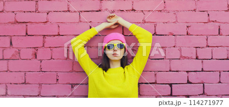 Portrait stylish young teenager girl in vivid colorful clothes, knitted yellow sweater and pink hat Portrait stylish young teenager girl in vivid colorful clothes, knitted yellow sweater and pink hat 114271977