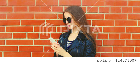 Modern caucasian young woman 20s model with mobile phone looking at device in the city 114271987