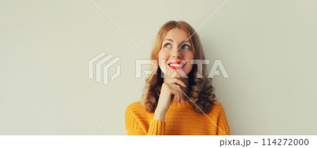 Pensive caucasian young woman thinks looking up Pensive caucasian young woman thinks looking up 114272000