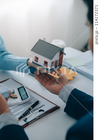 Real estate agent talked about the terms of the home purchase agreement and asked the customer to sign the documents to make the contract legally, Home sales and home insurance concept. 114272371