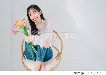 椅子に座って花束を持つ女性 椅子に座って花束を持つ女性 114272456