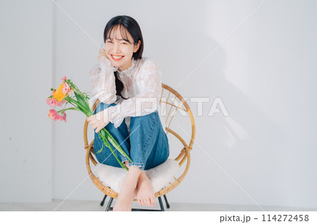 椅子に座って花束を持つ女性 椅子に座って花束を持つ女性 114272458