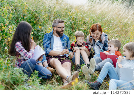Young students learning about nature, forest ecosystem during biology field teaching class, observing wild plants. Dedicated teachers during outdoor active education. Young students learning about nature, forest ecosystem during biology field teaching class, observing wild plants. Dedicated teachers during outdoor active education. 114273585